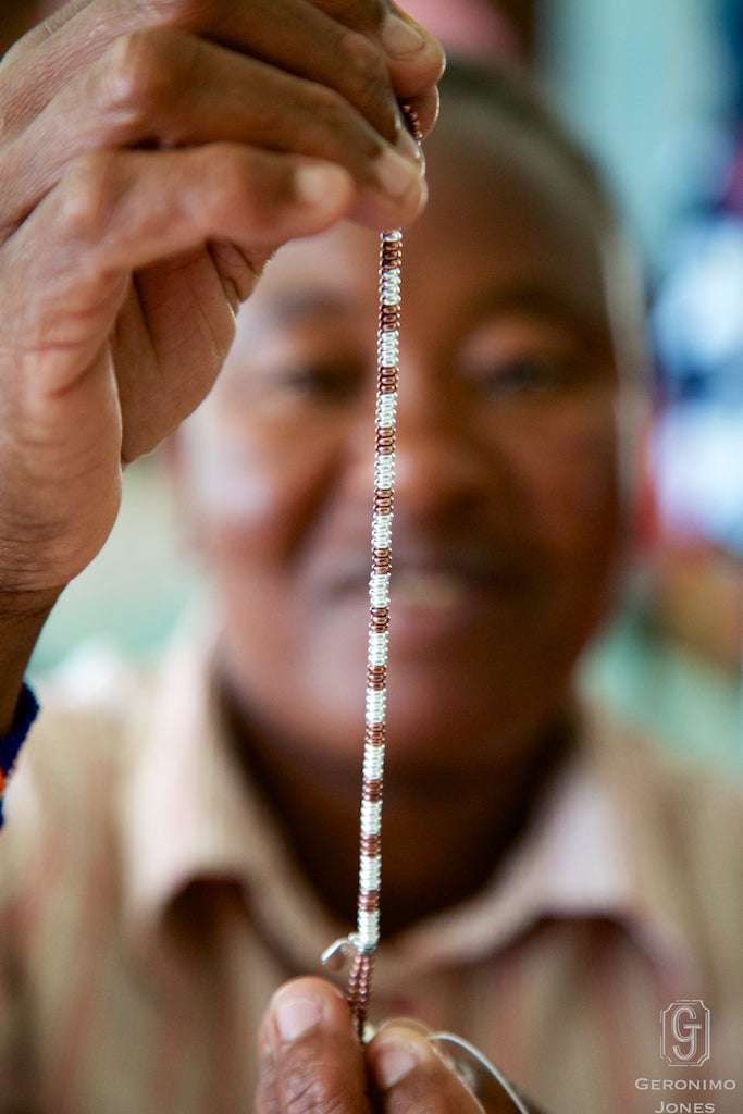 A Traditonal Kenyan Beader quality checks her handwork on the Geronimo Jones Tula Bracelet